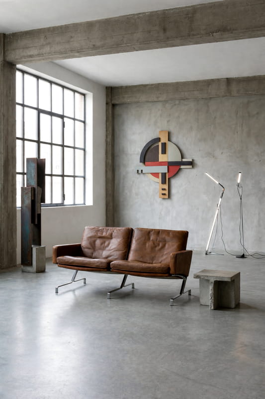 Brązowa skórzana sofa i lampa podłogowa w loftowym wnętrzu